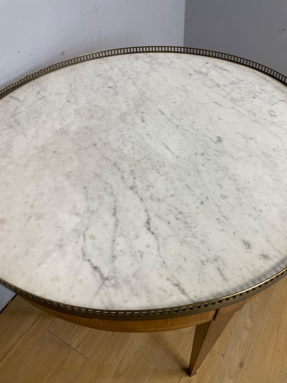 A late 19th-century French circular Bouillotte table featuring a white marble top with a pierced brass gallery, a veneered apron with a small drawer, and four square tapered legs ending in brass sabots. View VII