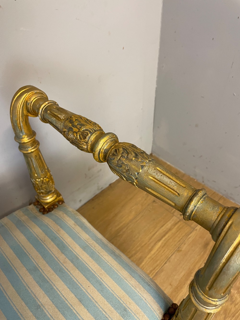 A Louis XVI style French giltwood window seat featuring rolled arms, fluted tapering legs, and blue and cream striped upholstery. View XI