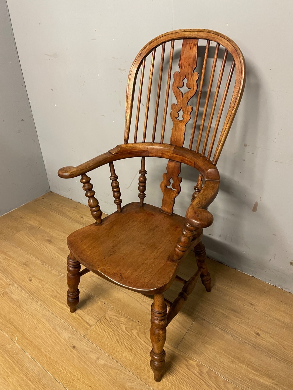A 19th-century ash and elm Windsor armchair featuring a hoop back, pierced central splat, turned arm supports, and a solid contoured seat. View II