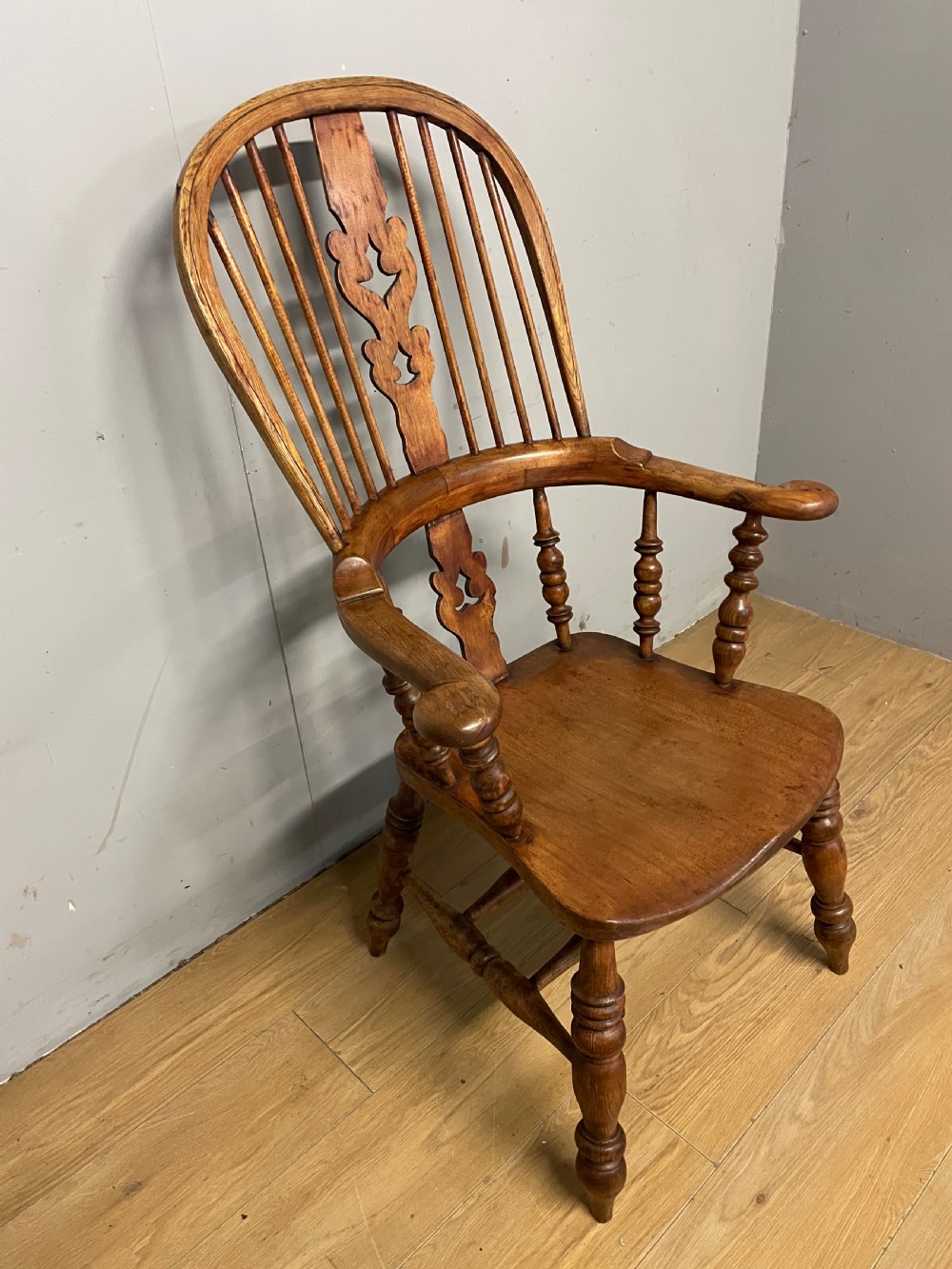 A 19th-century ash and elm Windsor armchair featuring a hoop back, pierced central splat, turned arm supports, and a solid contoured seat. View III