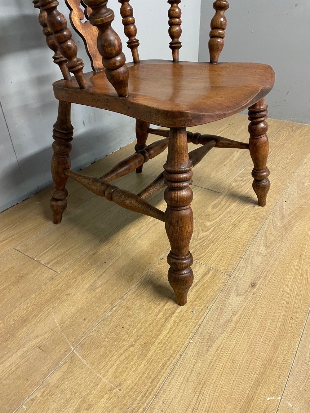 A 19th-century ash and elm Windsor armchair featuring a hoop back, pierced central splat, turned arm supports, and a solid contoured seat. View IV