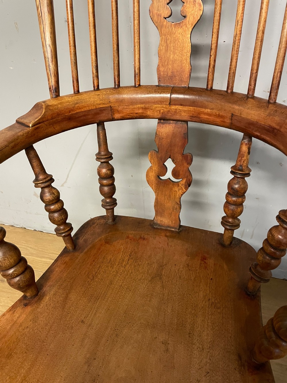 A 19th-century ash and elm Windsor armchair featuring a hoop back, pierced central splat, turned arm supports, and a solid contoured seat. View V