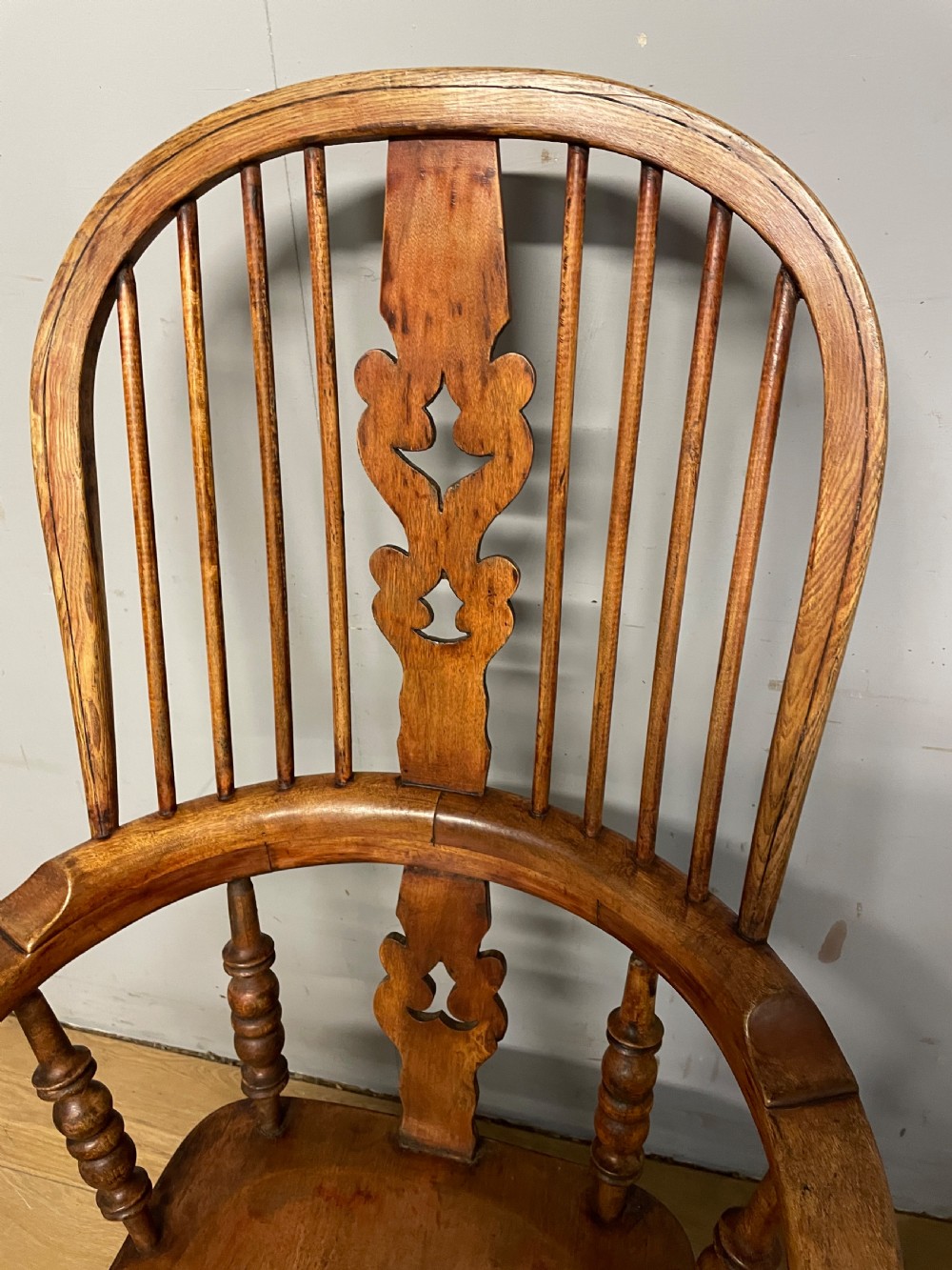 A 19th-century ash and elm Windsor armchair featuring a hoop back, pierced central splat, turned arm supports, and a solid contoured seat. View VI