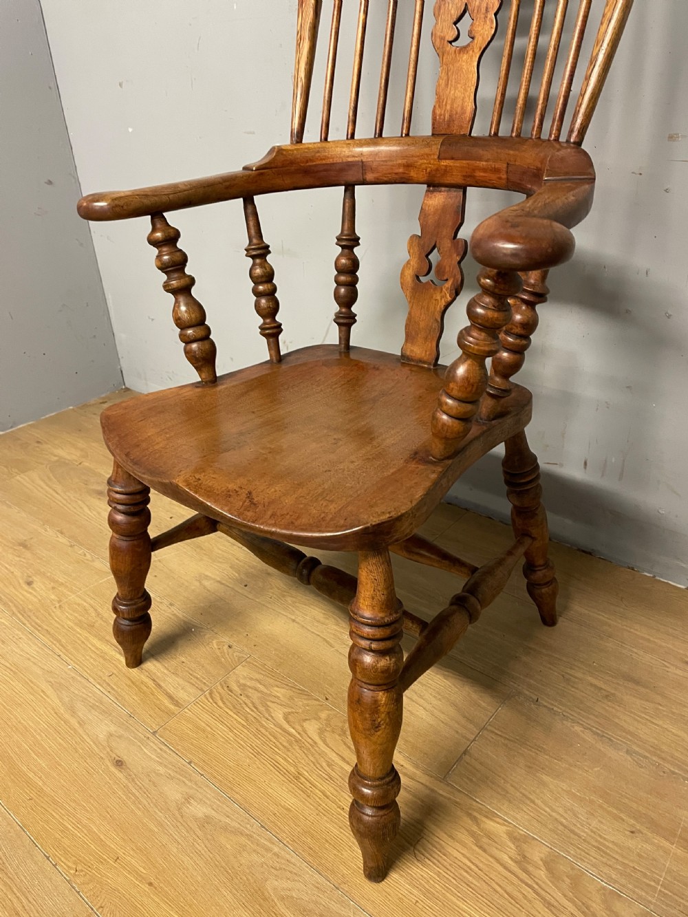 A 19th-century ash and elm Windsor armchair featuring a hoop back, pierced central splat, turned arm supports, and a solid contoured seat. View VII