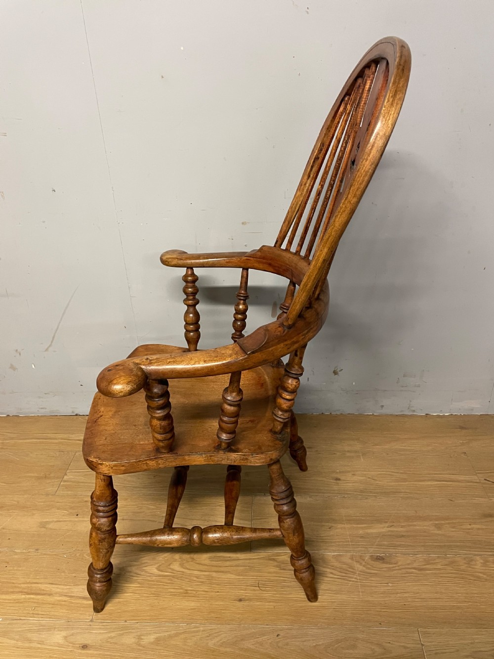 A 19th-century ash and elm Windsor armchair featuring a hoop back, pierced central splat, turned arm supports, and a solid contoured seat. View XI