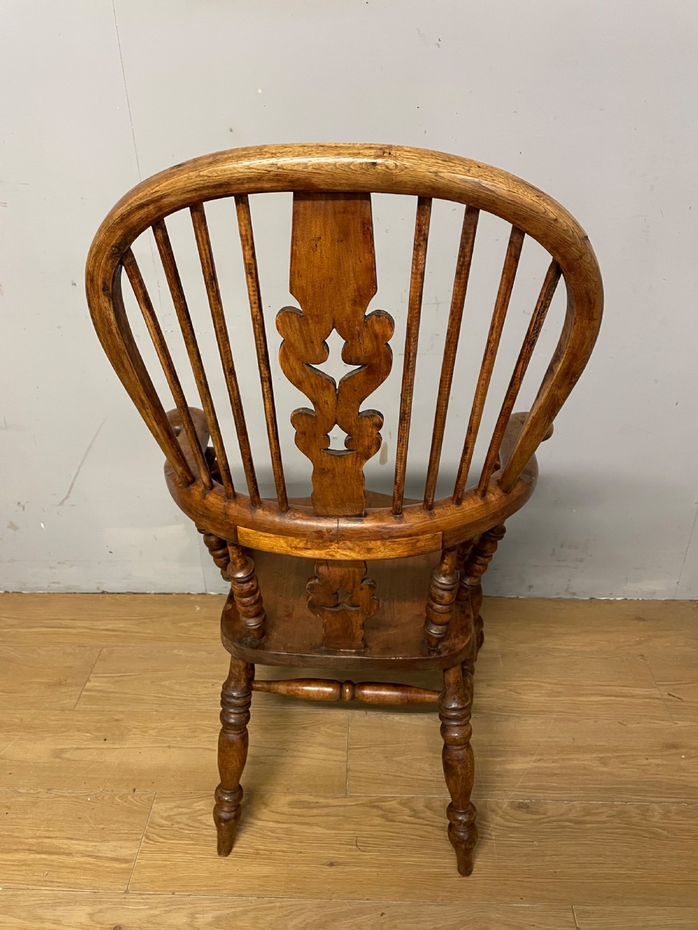 A 19th-century ash and elm Windsor armchair featuring a hoop back, pierced central splat, turned arm supports, and a solid contoured seat. View XII