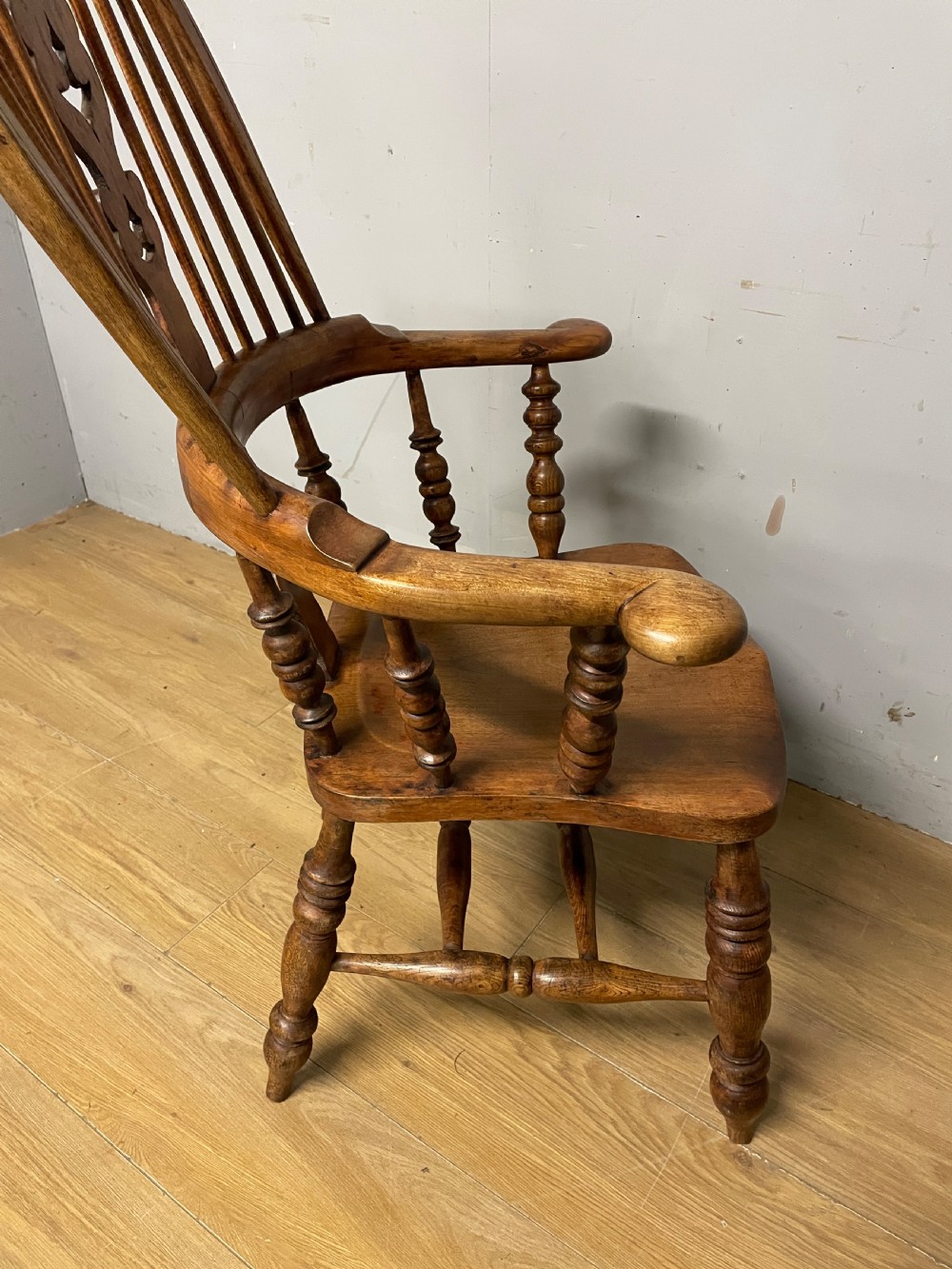 A 19th-century ash and elm Windsor armchair featuring a hoop back, pierced central splat, turned arm supports, and a solid contoured seat. View XIII