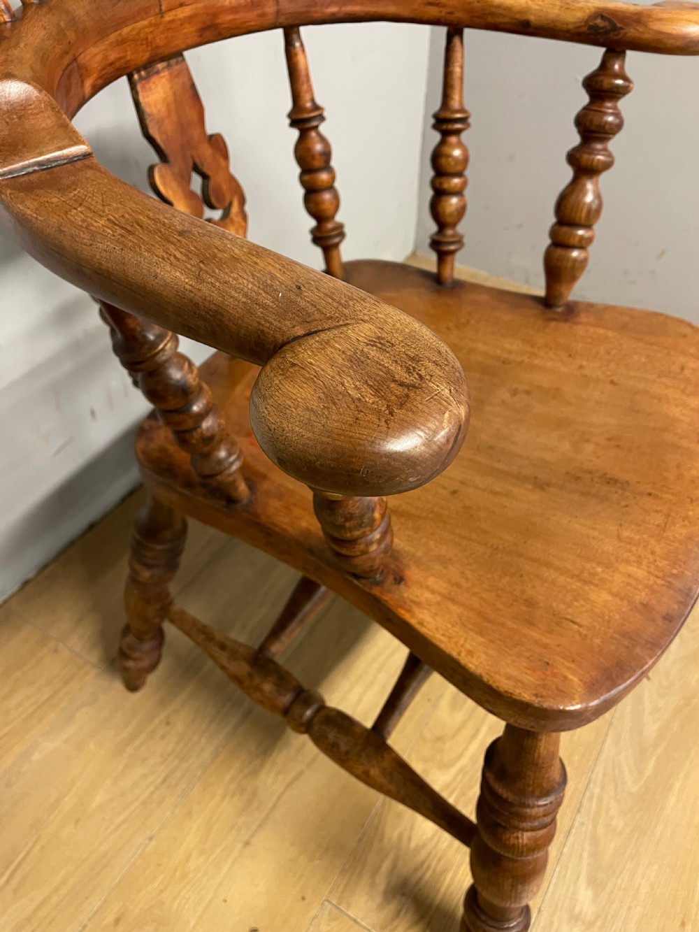 A 19th-century ash and elm Windsor armchair featuring a hoop back, pierced central splat, turned arm supports, and a solid contoured seat. View XIV