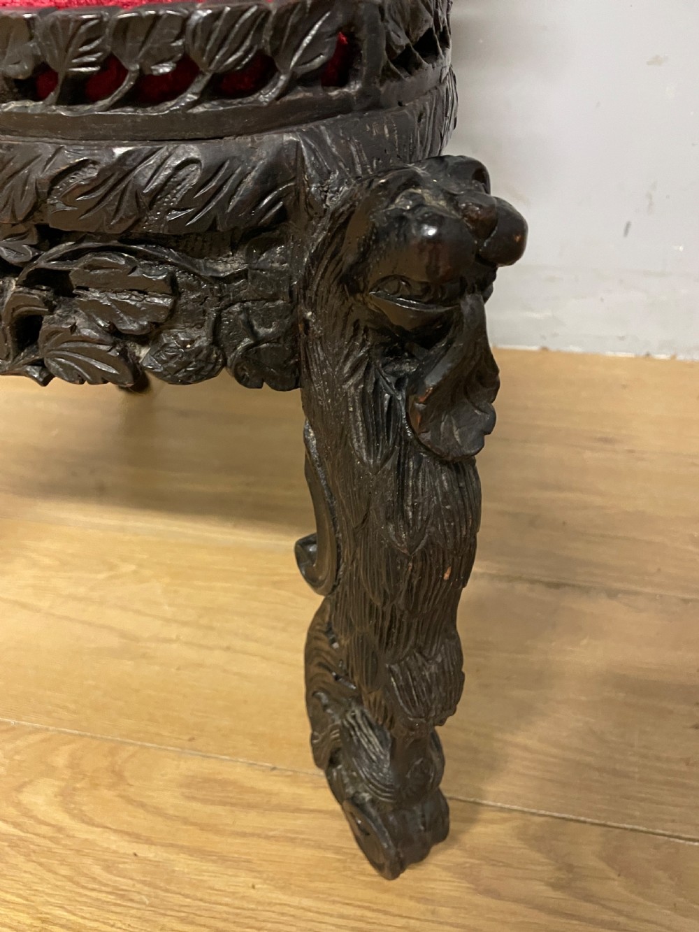 A 19th-century Burmese side chair featuring an intricately carved dark wood openwork backrest and animal-shaped cabriole legs with a red velvet upholstered seat. View XIII