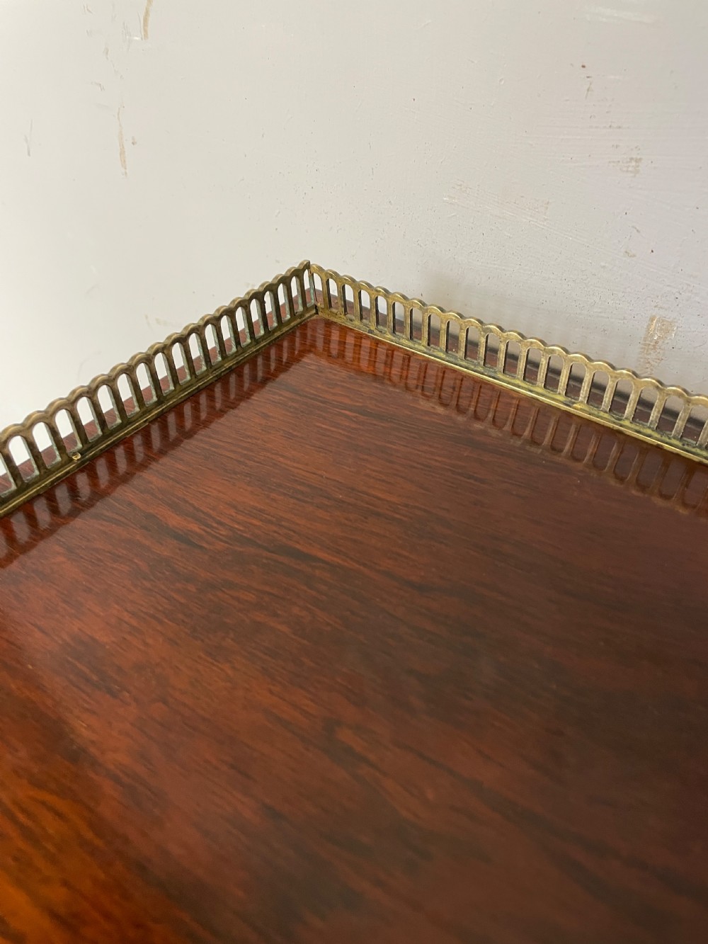 A late Regency rosewood chiffonier featuring barley twist columns, brass wire lattice doors backed with green pleated fabric, and a brass gallery top rail. View XI