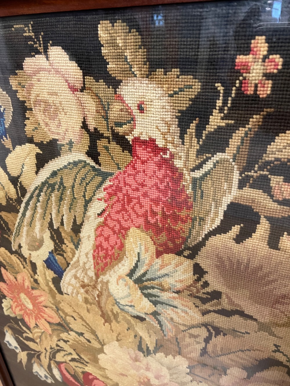 A nineteenth-century mahogany firescreen featuring a central needlepoint panel depicting a floral arrangement and bird, supported by carved splayed legs and a turned stretcher. View VI