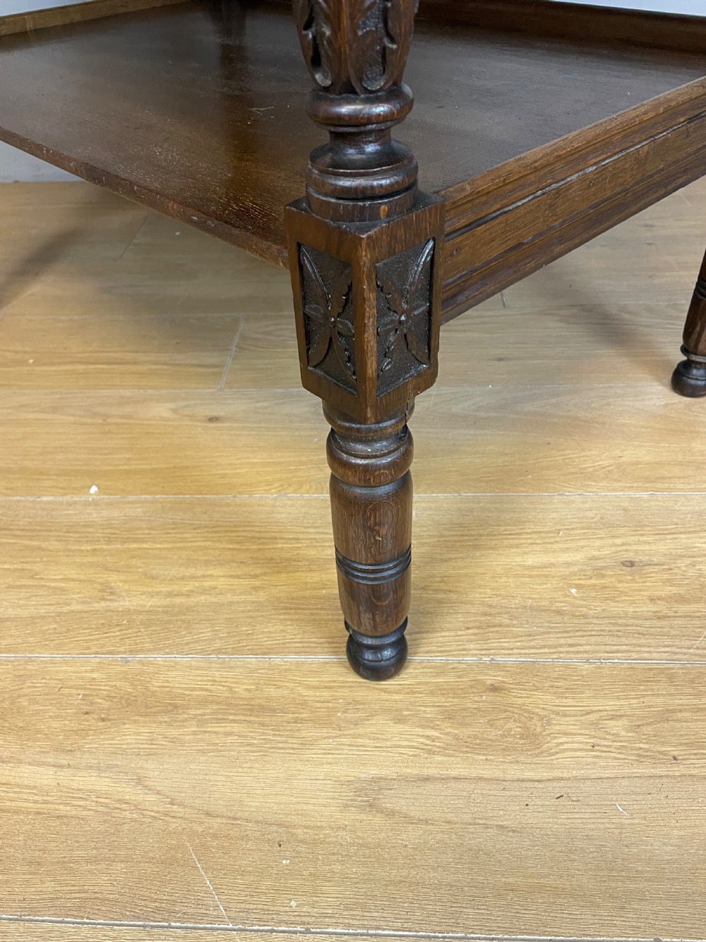 A 19th-century dark carved oak two-tier side table featuring turned legs and a detailed carved frieze. View VIII