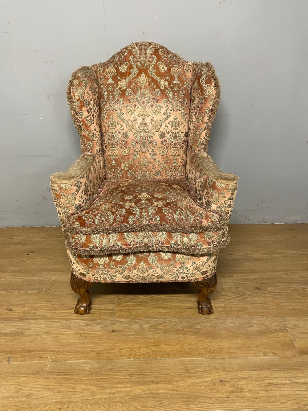 An early twentieth-century Georgian style wing armchair upholstered in patterned terracotta velvet with carved cabriole front legs ending in ball and claw feet. View II
