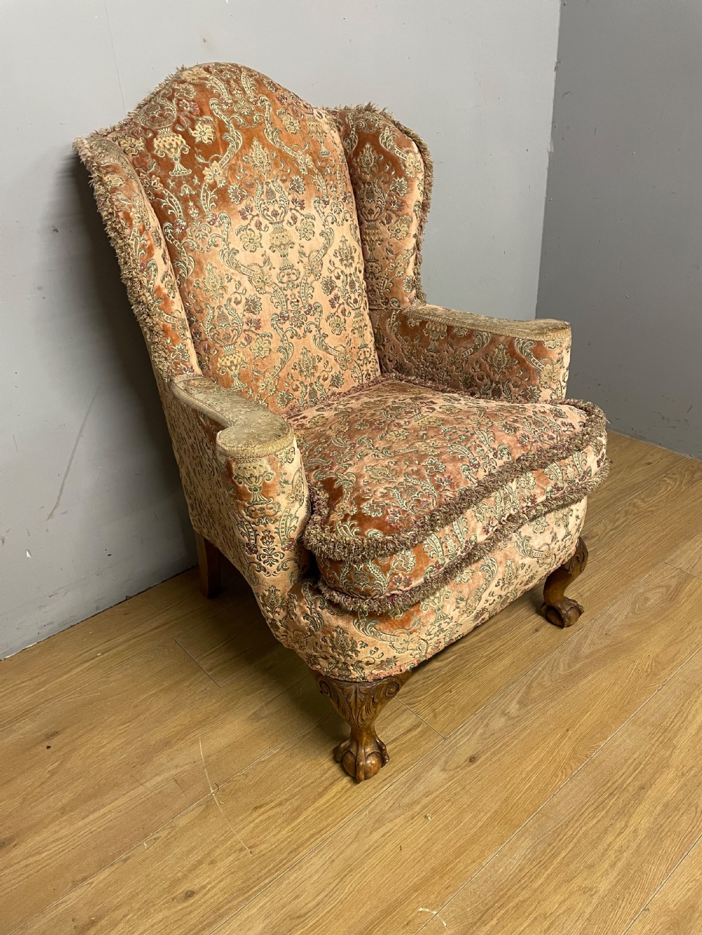An early twentieth-century Georgian style wing armchair upholstered in patterned terracotta velvet with carved cabriole front legs ending in ball and claw feet. View III