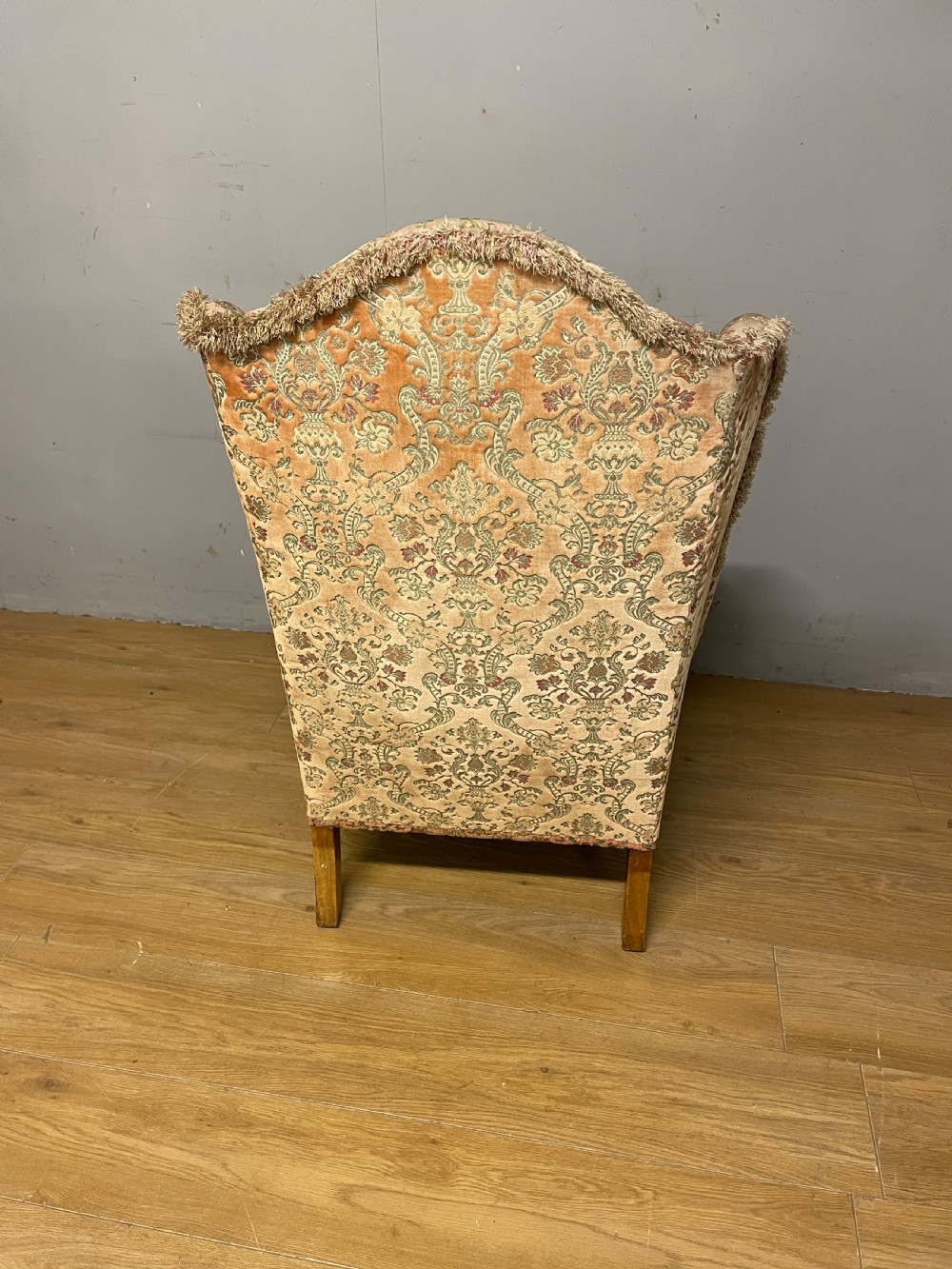 An early twentieth-century Georgian style wing armchair upholstered in patterned terracotta velvet with carved cabriole front legs ending in ball and claw feet. View VIII