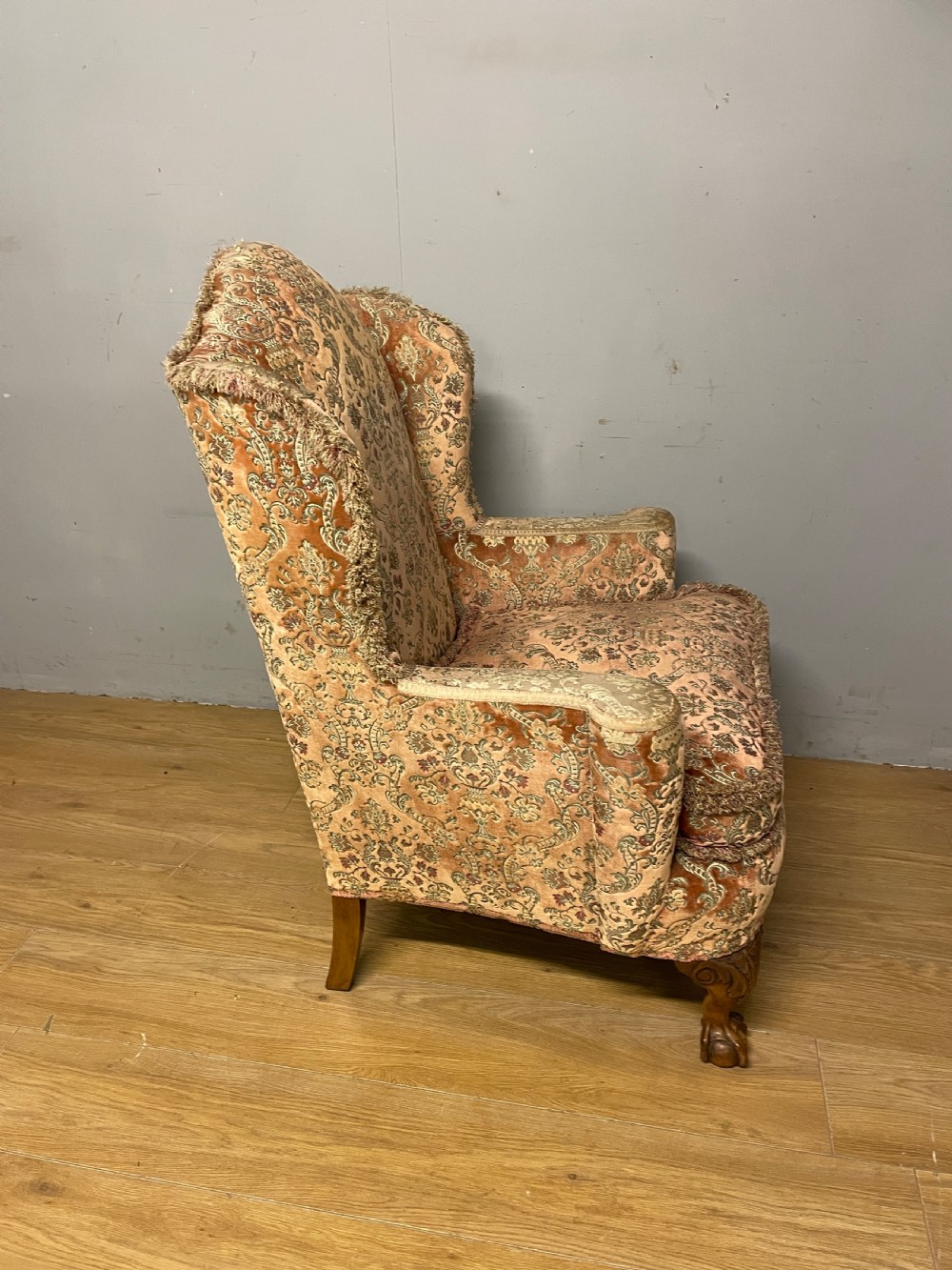 An early twentieth-century Georgian style wing armchair upholstered in patterned terracotta velvet with carved cabriole front legs ending in ball and claw feet. View IX