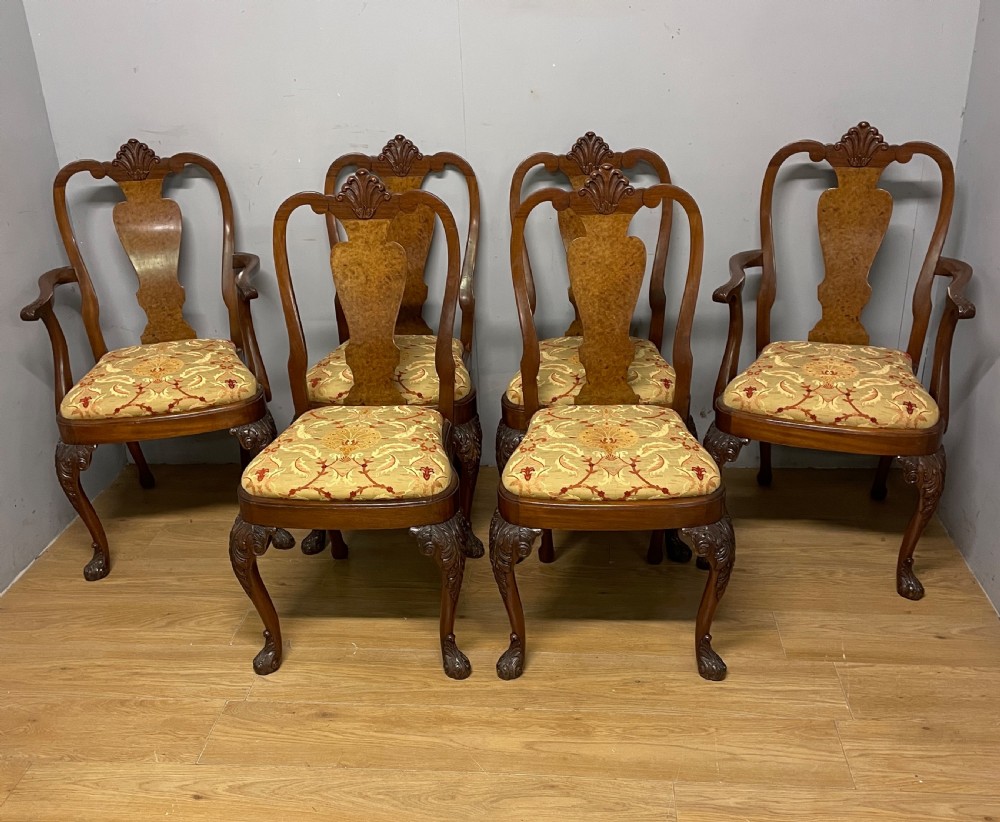 An early twentieth-century Georgian style wing armchair upholstered in patterned terracotta velvet with carved cabriole front legs ending in ball and claw feet. View X