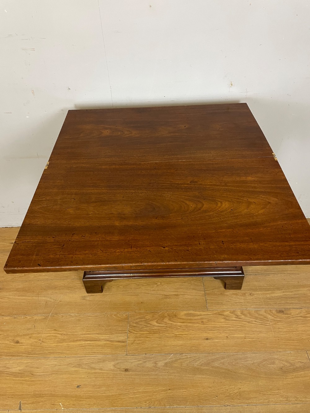 A 19th-century mahogany bachelors chest of drawers featuring a fold-over top, brass drop handles, side carrying handles, and bracket feet. View VIII