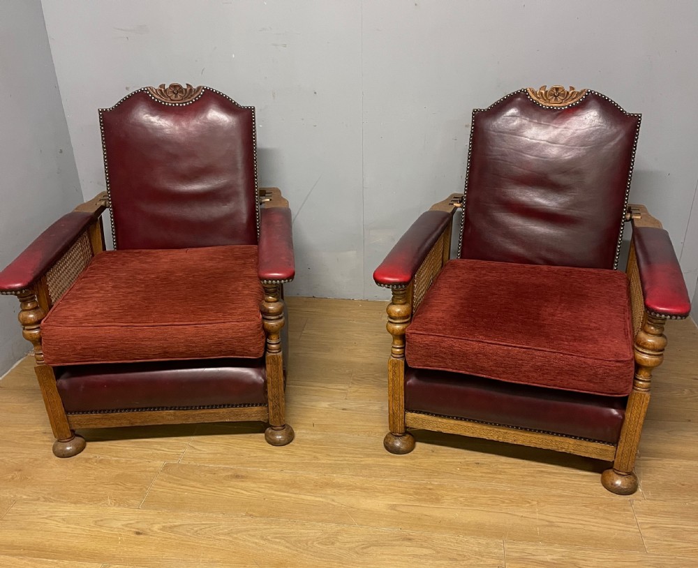 Pair of Arts and Crafts golden oak reclining leather library chairs 