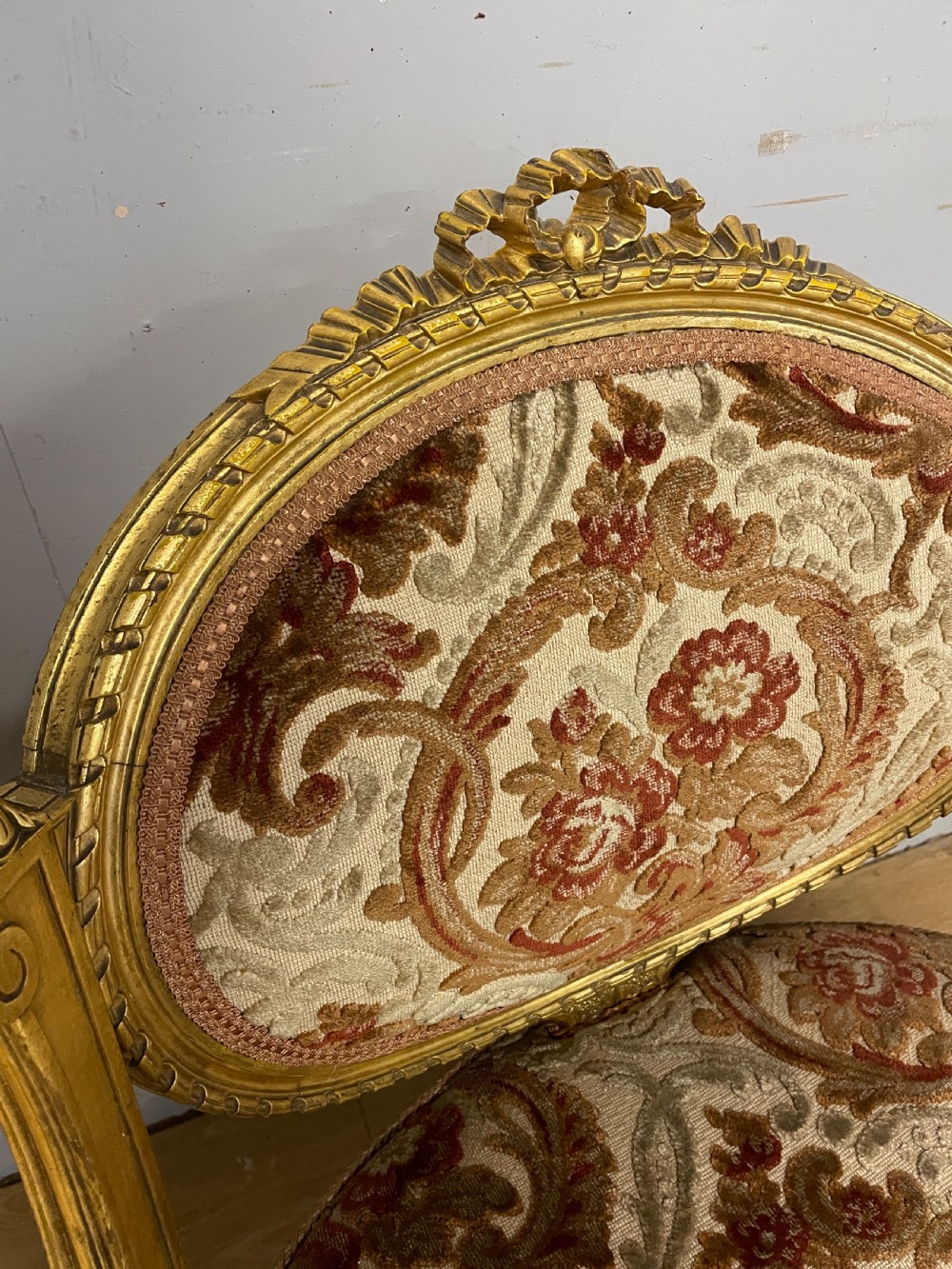 A 19th-century carved giltwood nursing chair featuring patterned burgundy velvet upholstery, an oval backrest, and short turned legs with castors. View IV