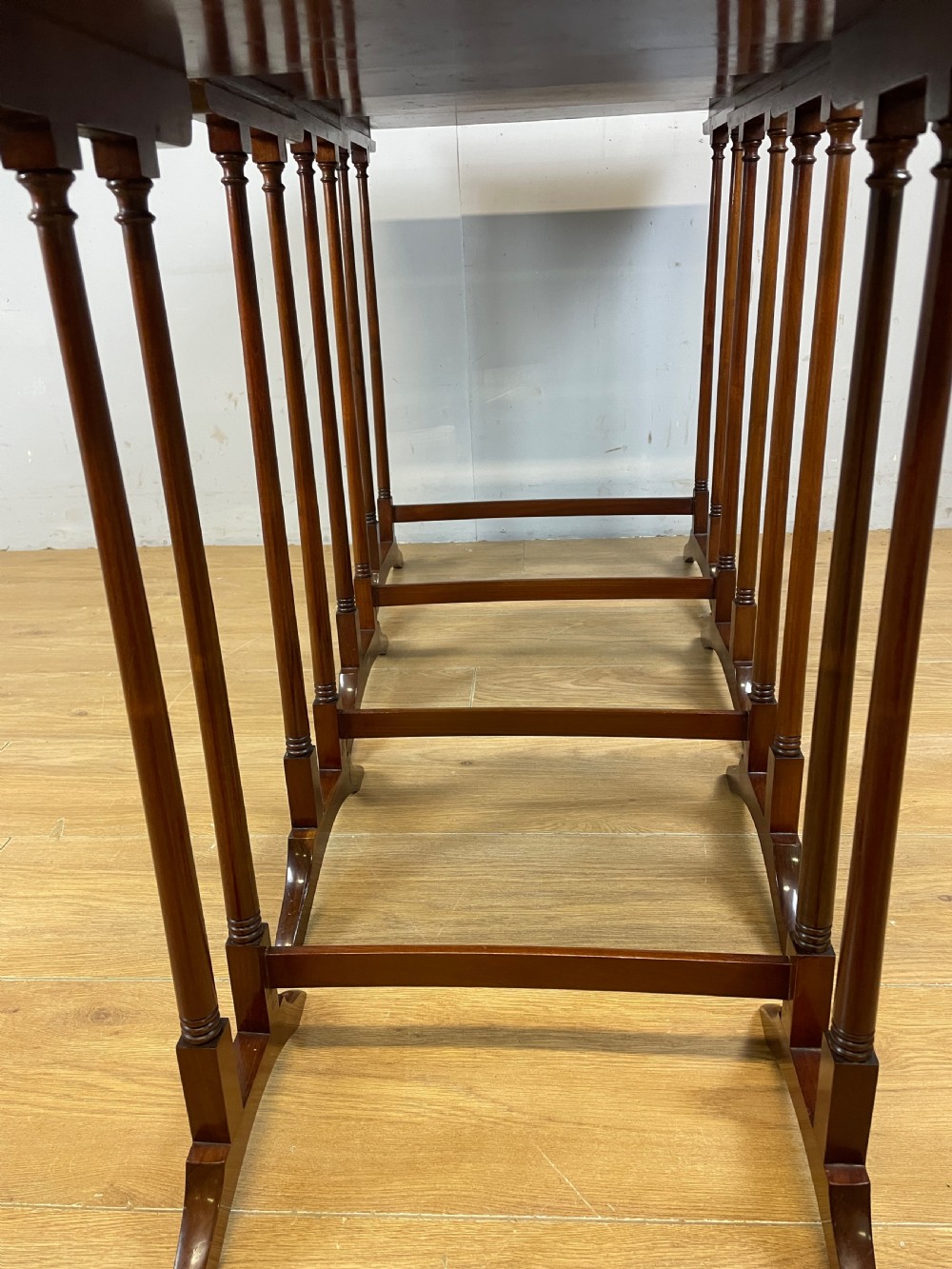 An Edwardian nest of four rectangular mahogany tables featuring satinwood floral line inlay and slender turned legs resting on trestle feet. View VIII