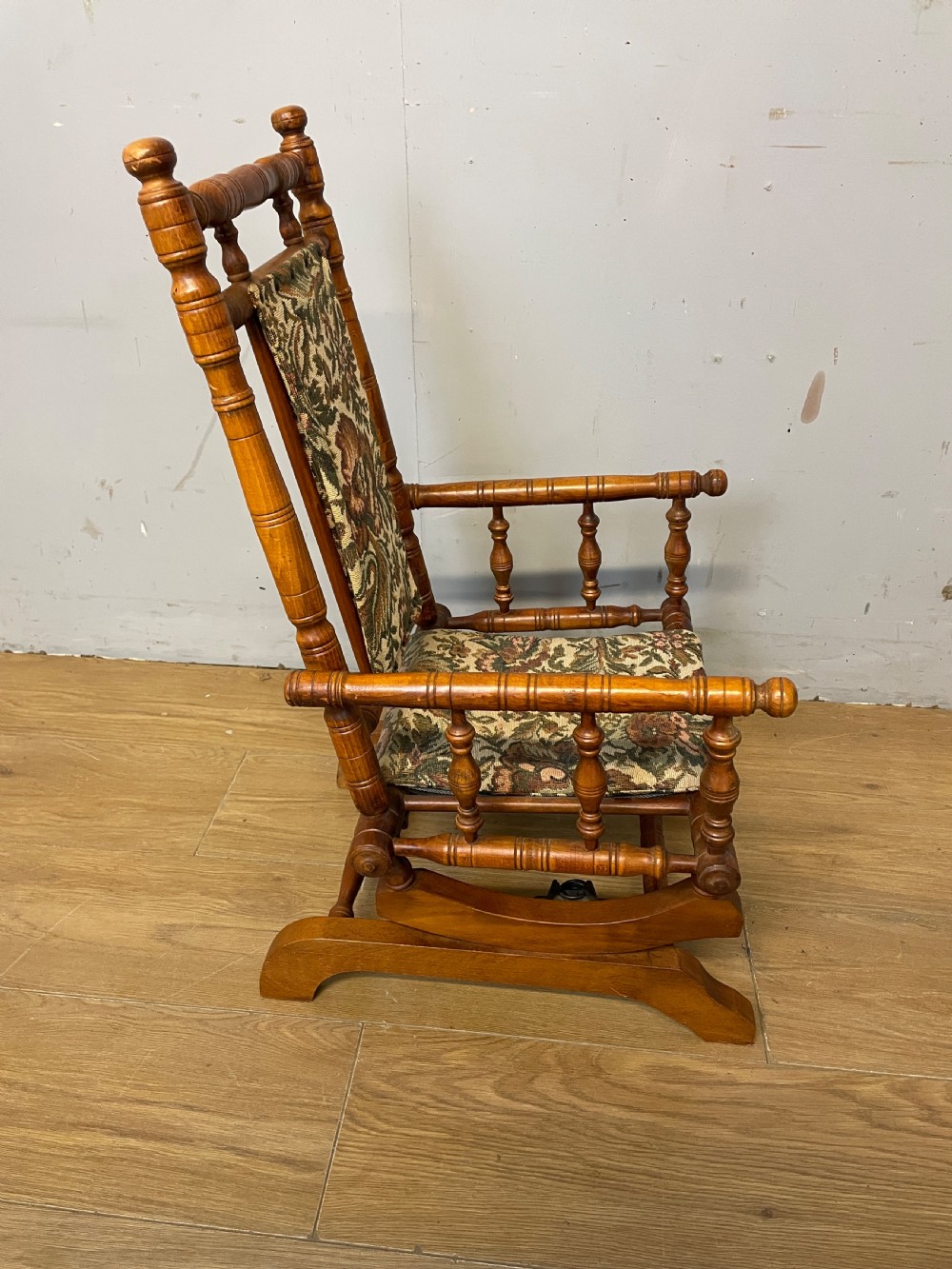 A 19th-century childs American platform rocking chair made of turned wood with floral tapestry fabric on the seat and backrest. View IV
