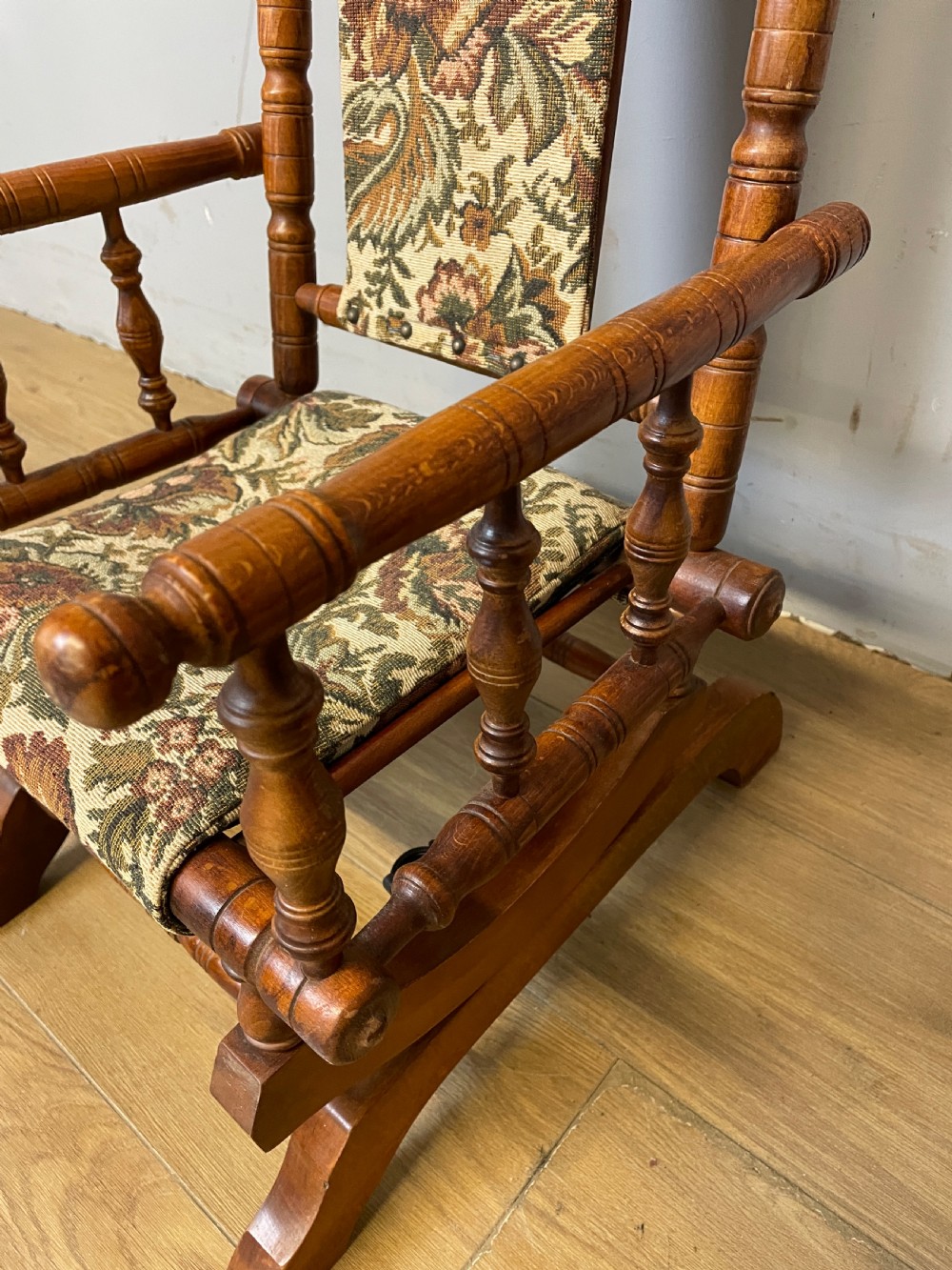 A 19th-century childs American platform rocking chair made of turned wood with floral tapestry fabric on the seat and backrest. View VII