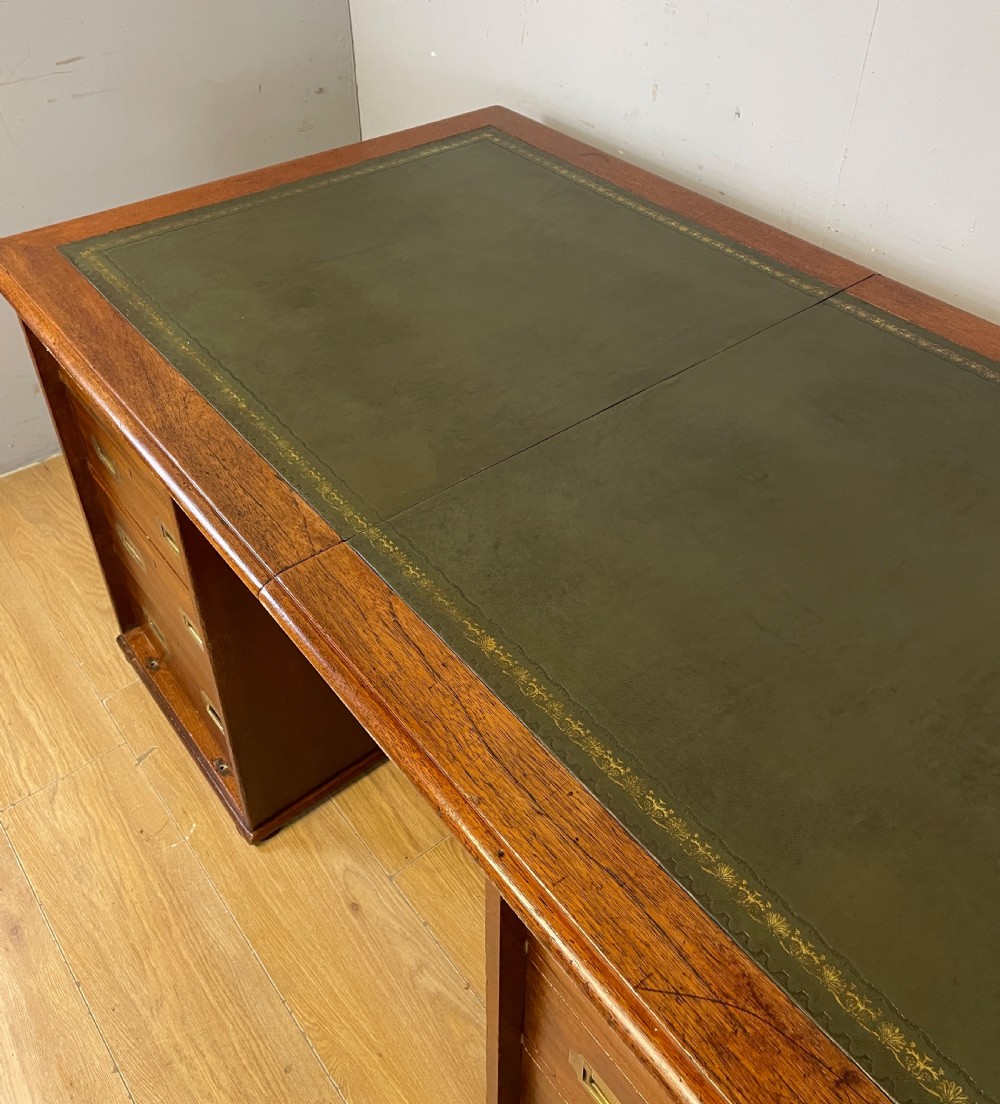 A 19th-century teak three-part military campaign desk featuring a green leather inset writing surface and flush brass drawer handles. View V