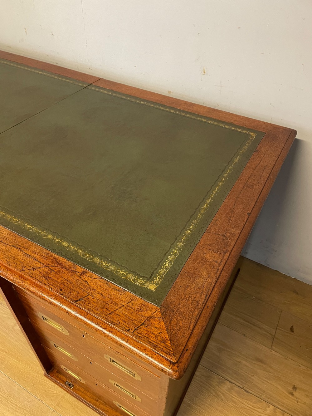 A 19th-century teak three-part military campaign desk featuring a green leather inset writing surface and flush brass drawer handles. View VI