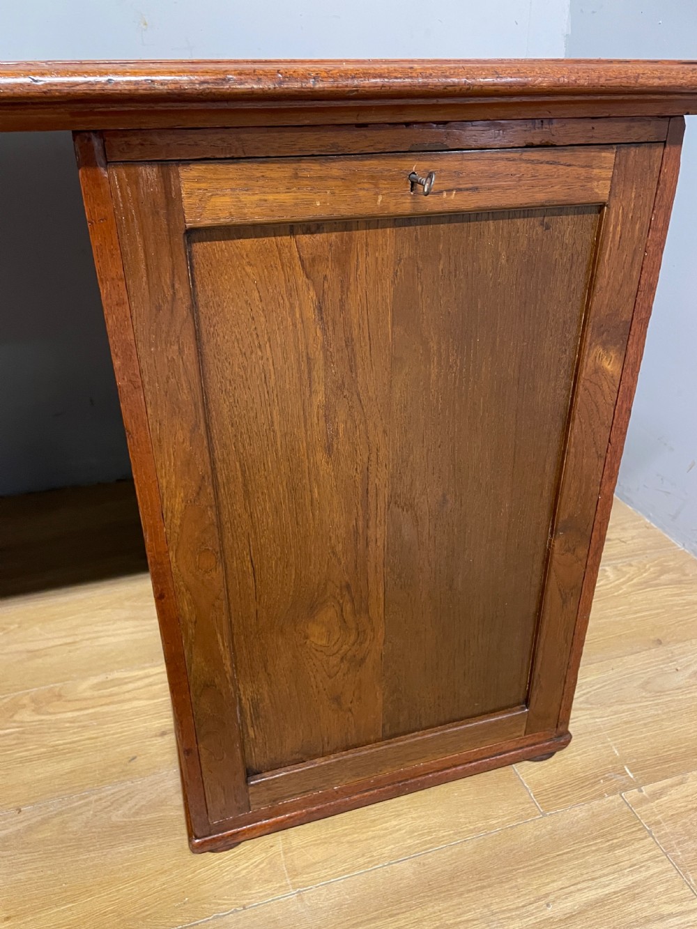 A 19th-century teak three-part military campaign desk featuring a green leather inset writing surface and flush brass drawer handles. View X