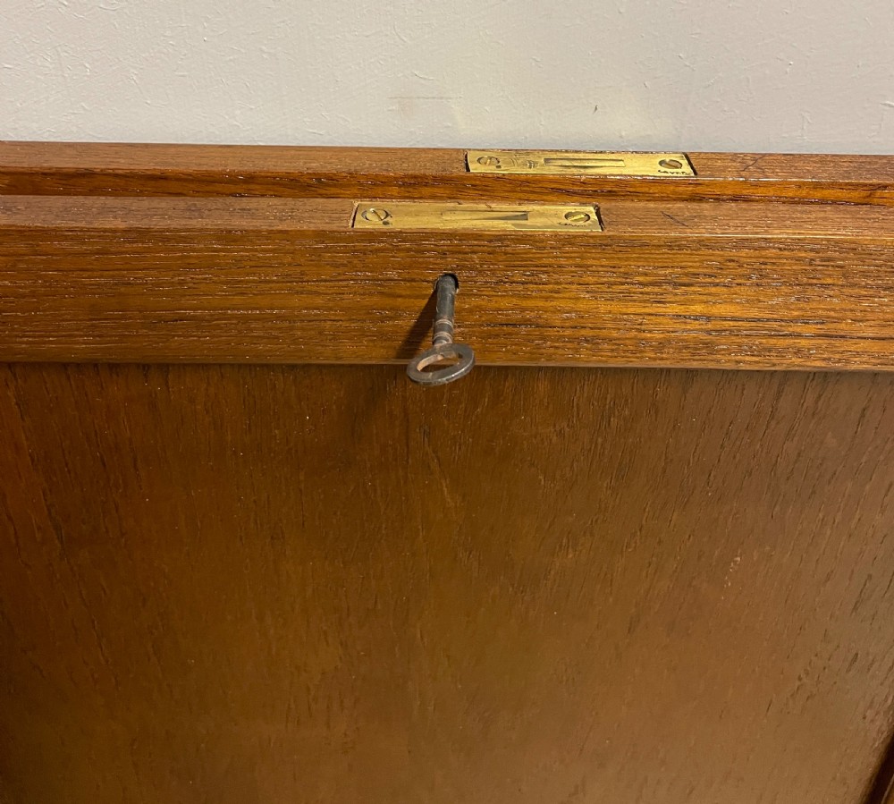 A 19th-century teak three-part military campaign desk featuring a green leather inset writing surface and flush brass drawer handles. View XI