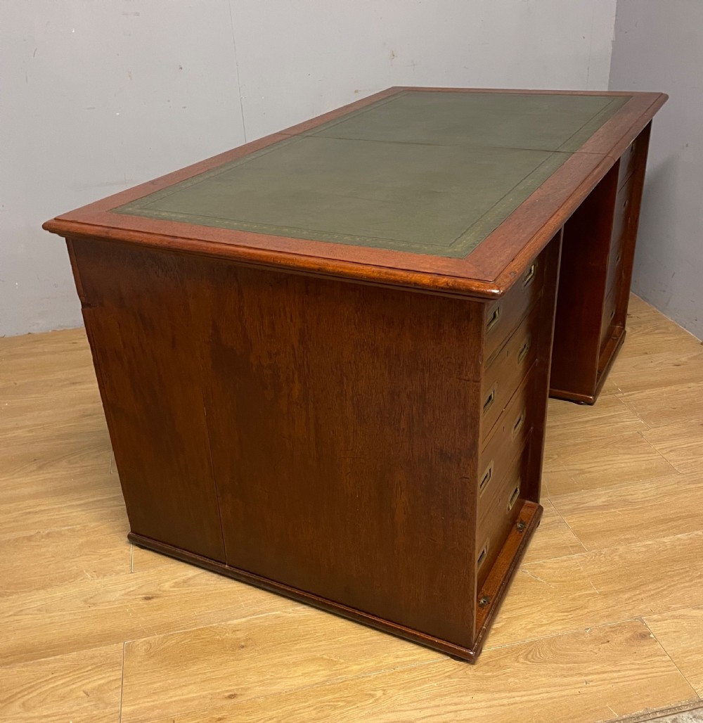 A 19th-century teak three-part military campaign desk featuring a green leather inset writing surface and flush brass drawer handles. View XII