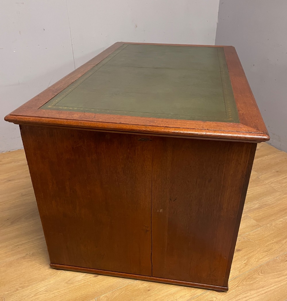 A 19th-century teak three-part military campaign desk featuring a green leather inset writing surface and flush brass drawer handles. View XVI