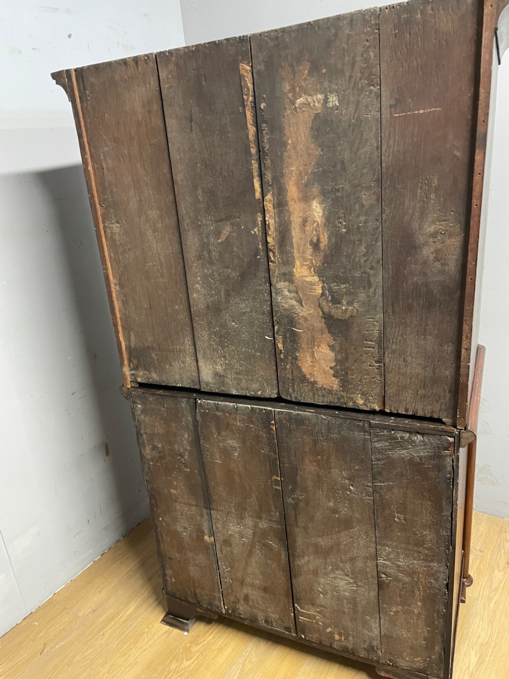 A nineteenth-century burr walnut chest on chest with multiple drawers, brass drop handles, keyhole escutcheons, and bracket feet. View X