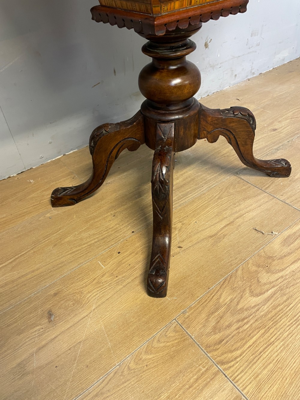 A 19th-century Victorian walnut sewing and games table featuring an inlaid chessboard top, a tapered central storage well, and a carved pedestal base. View V
