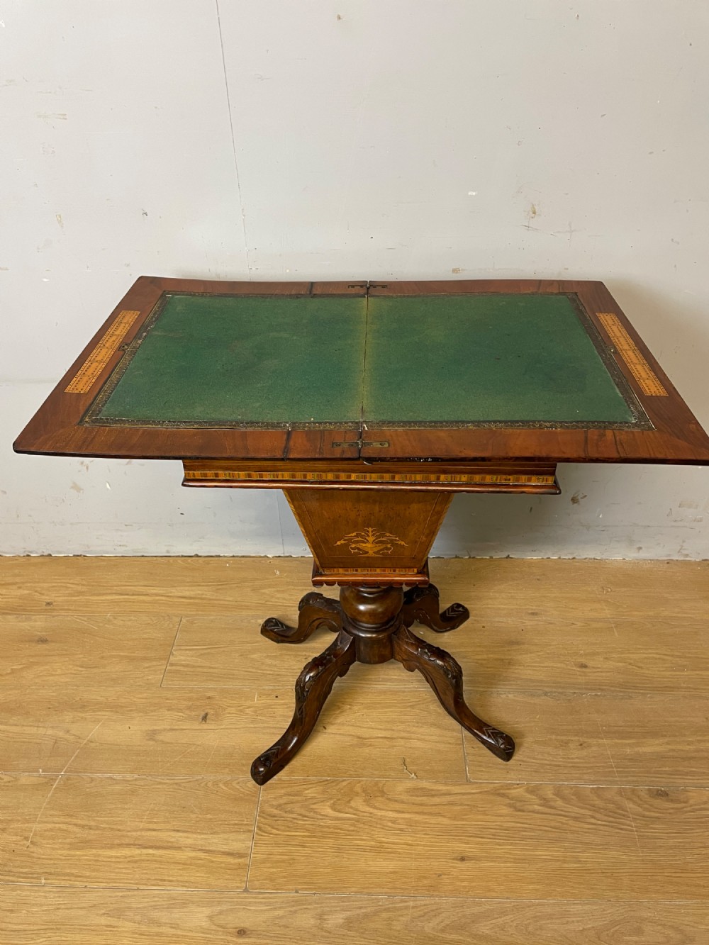 A 19th-century Victorian walnut sewing and games table featuring an inlaid chessboard top, a tapered central storage well, and a carved pedestal base. View IX