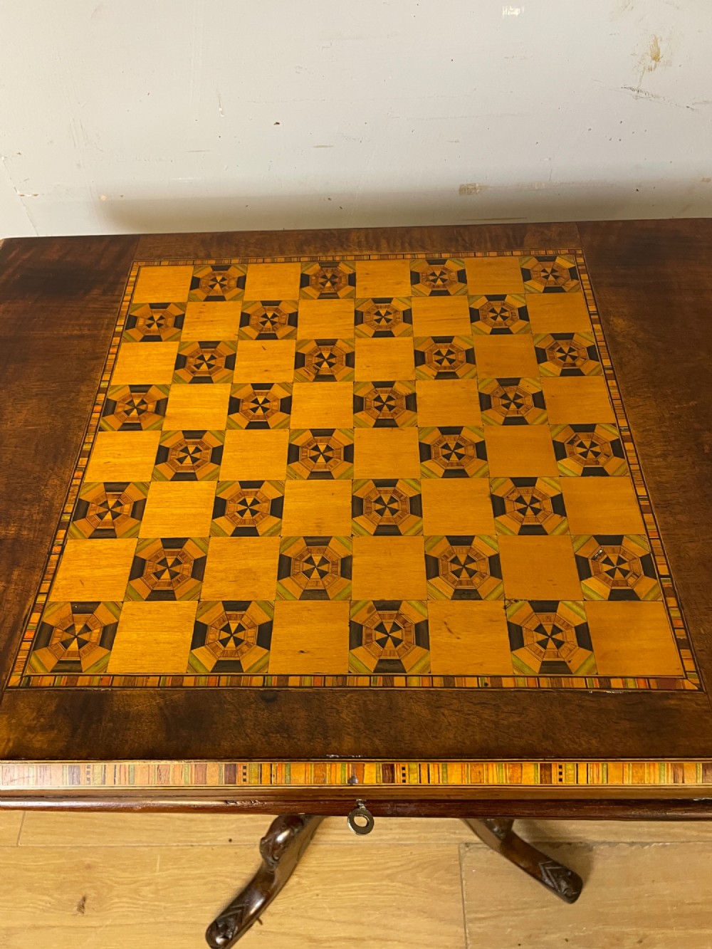 A 19th-century Victorian walnut sewing and games table featuring an inlaid chessboard top, a tapered central storage well, and a carved pedestal base. View XIV