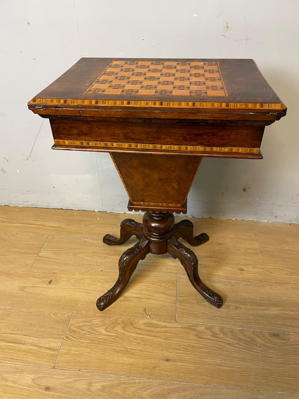 A 19th-century Victorian walnut sewing and games table featuring an inlaid chessboard top, a tapered central storage well, and a carved pedestal base. View XV
