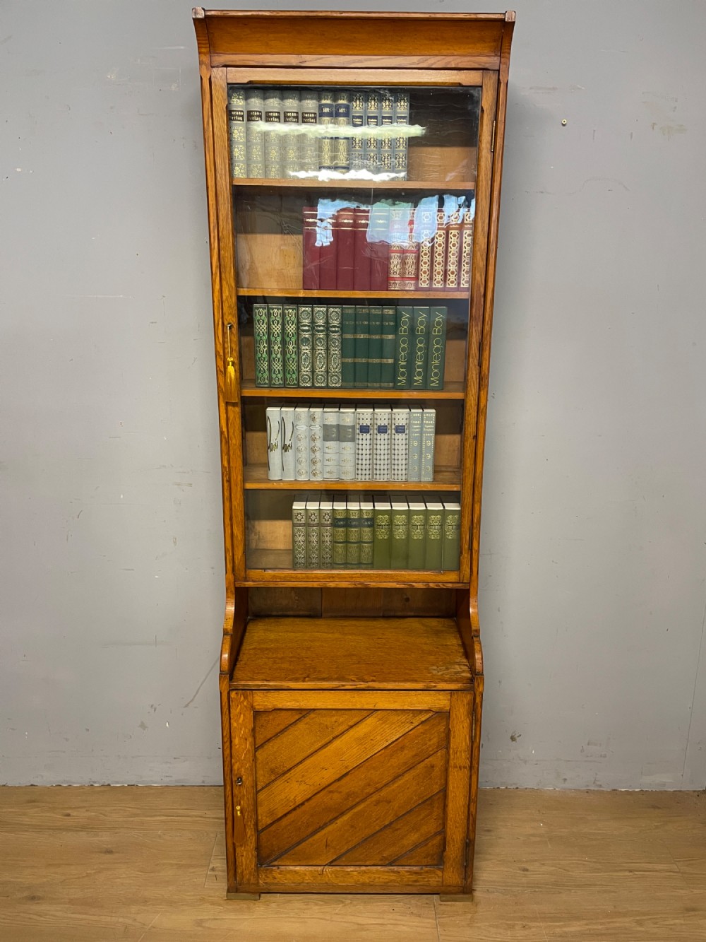 Arts and Crafts golden oak slim bookcase over cupboard View II