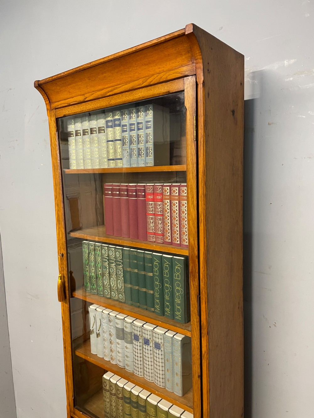 Arts and Crafts golden oak slim bookcase over cupboard View III