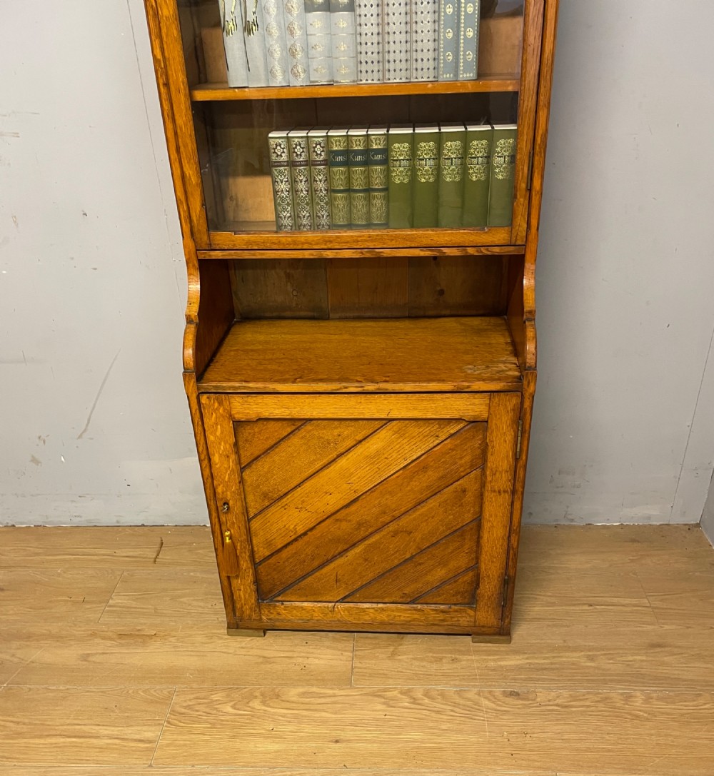 Arts and Crafts golden oak slim bookcase over cupboard View XII