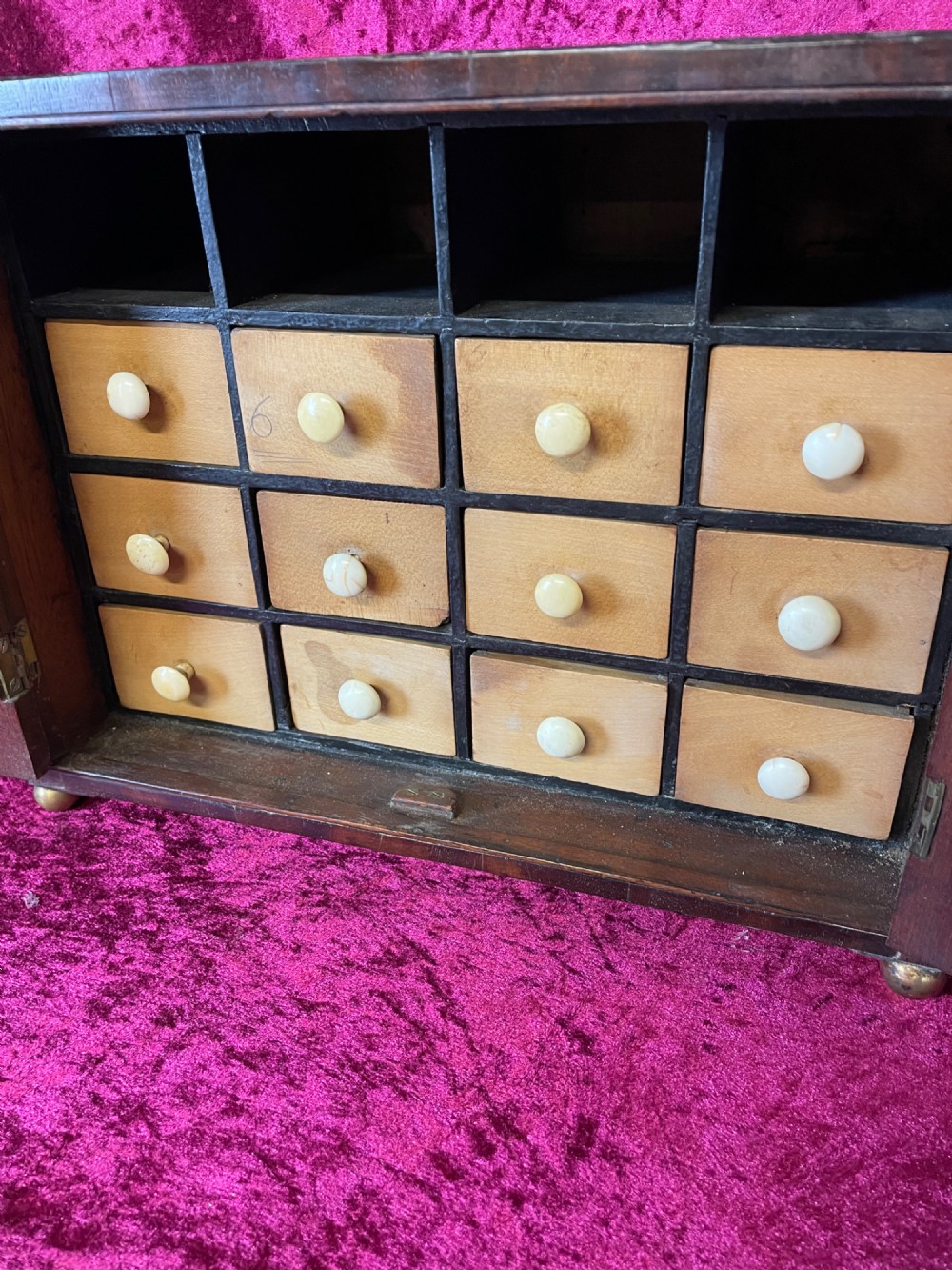 A Georgian dark mahogany tabletop cabinet featuring double doors with oval marquetry urn inlays, diamond escutcheons, and brass ball feet. View VII