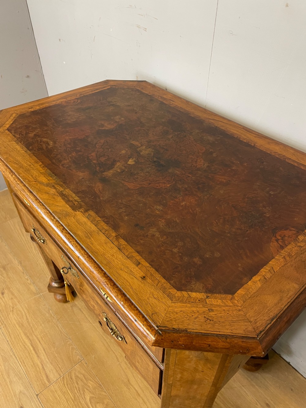A late Victorian burr walnut lowboy featuring two drawers with brass handles, carved legs, and a shaped cross-stretcher. View III