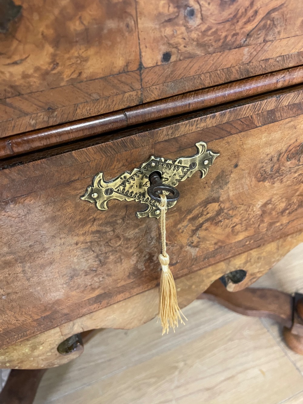 A late Victorian burr walnut lowboy featuring two drawers with brass handles, carved legs, and a shaped cross-stretcher. View VII