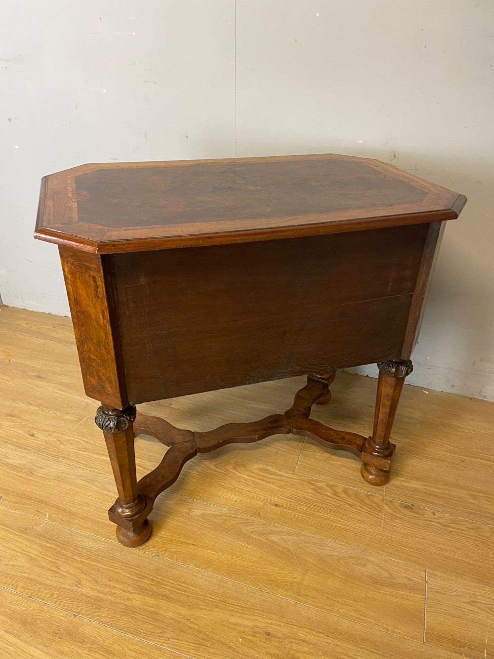 A late Victorian burr walnut lowboy featuring two drawers with brass handles, carved legs, and a shaped cross-stretcher. View XII