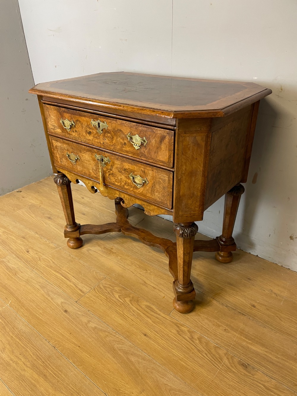 A late Victorian burr walnut lowboy featuring two drawers with brass handles, carved legs, and a shaped cross-stretcher. View XIII