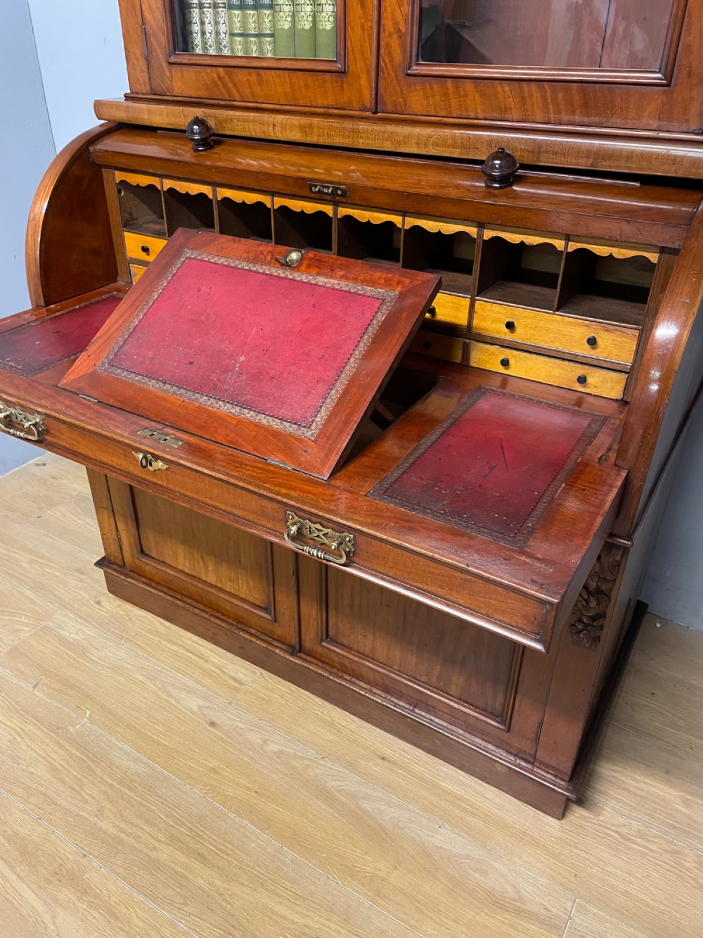 A 19th-century mahogany cylinder bureau bookcase featuring an upper glazed cabinet with two arched doors, a roll-top writing section, and a lower two-door cupboard. View VII