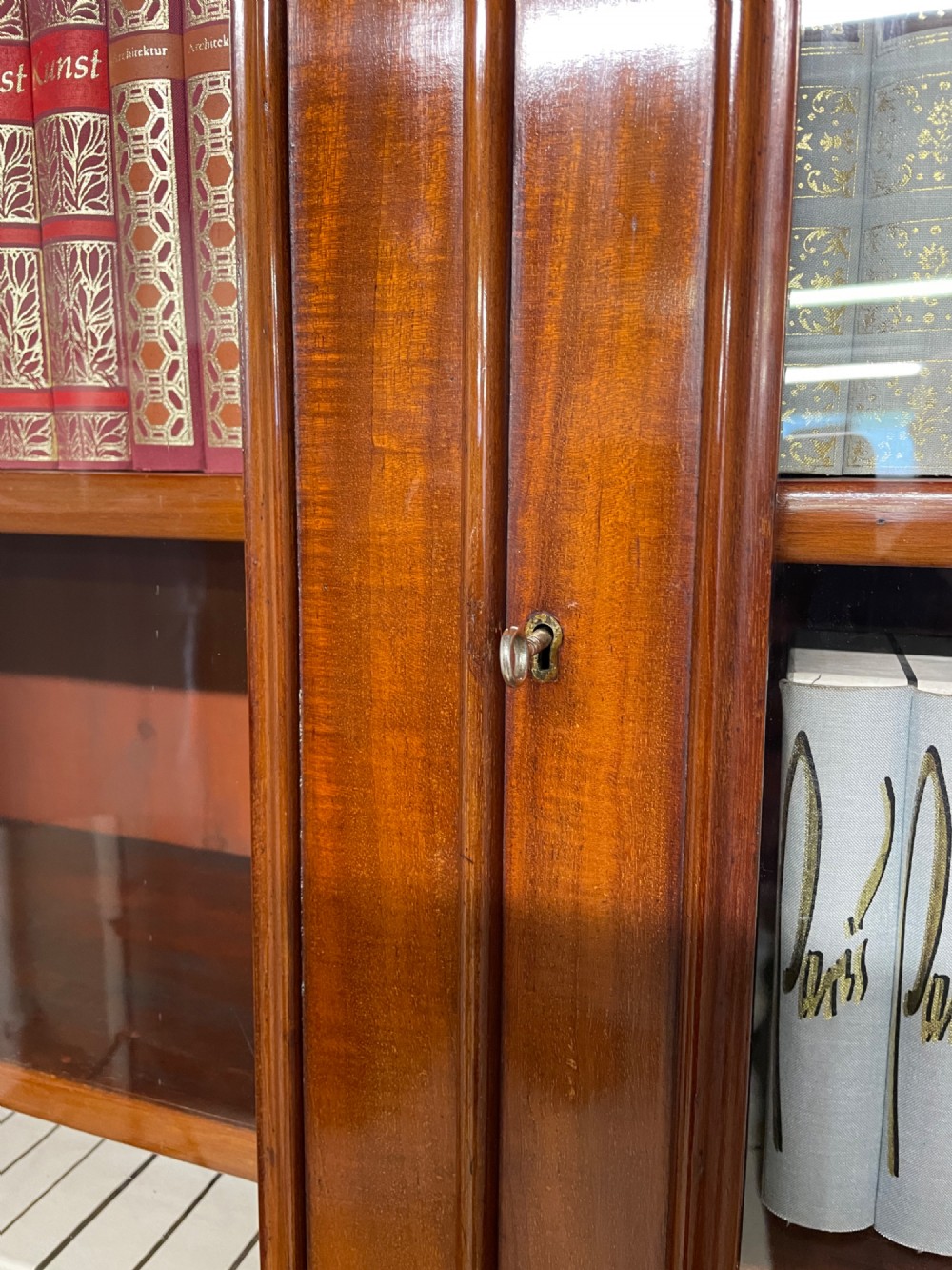 A 19th-century mahogany cylinder bureau bookcase featuring an upper glazed cabinet with two arched doors, a roll-top writing section, and a lower two-door cupboard. View IX