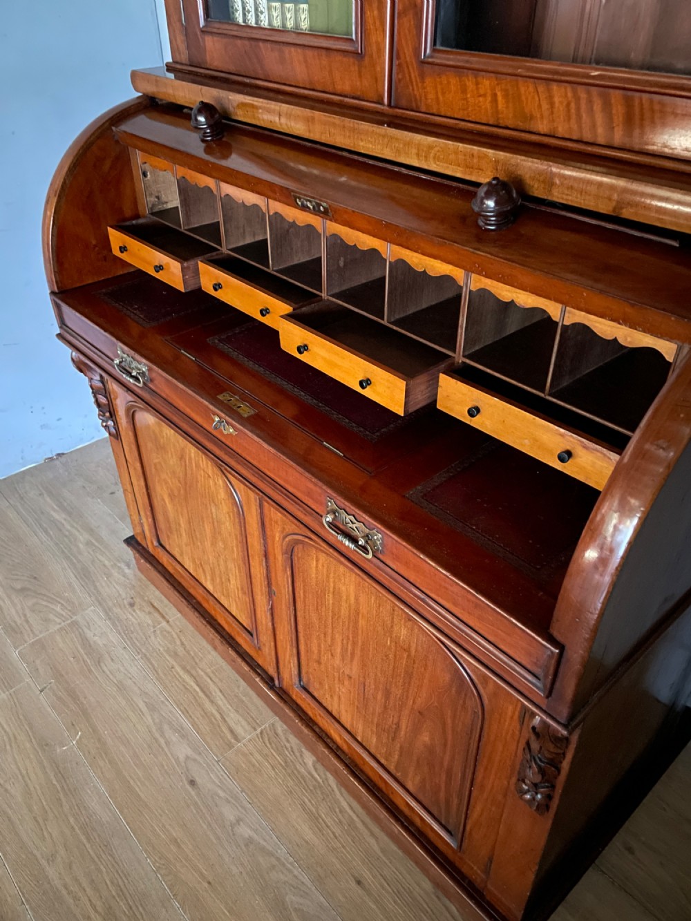 A 19th-century mahogany cylinder bureau bookcase featuring an upper glazed cabinet with two arched doors, a roll-top writing section, and a lower two-door cupboard. View XIII