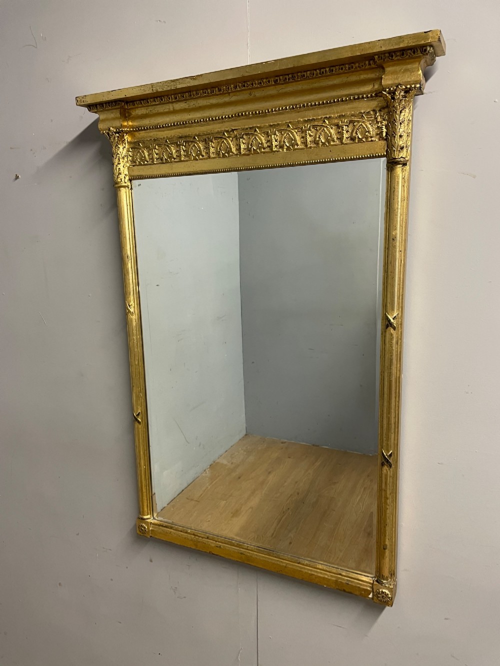 A rectangular giltwood wall mirror featuring a projecting cornice top, classical column pilasters, arcaded frieze details, and rosette corner blocks. View II